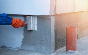 A,Worker,Is,Applying,Waterproofing,Paint,To,The,Wall.,Applying