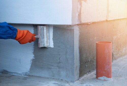 A,Worker,Is,Applying,Waterproofing,Paint,To,The,Wall.,Applying